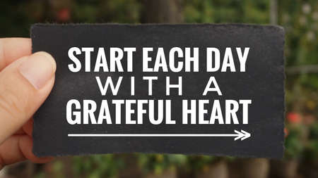 Motivational and inspirational quote - âStart each day with a grateful heartâ written on a paper. Vintage styled background.の写真素材