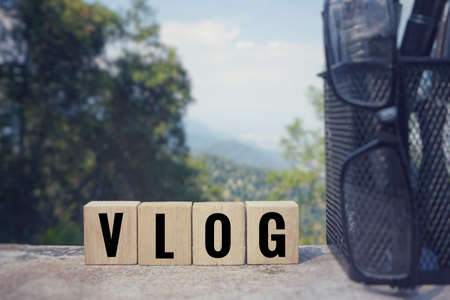 Hobbies and leisure concept - âVLOGâ written on wooden blocks. Blurred styled background.の写真素材
