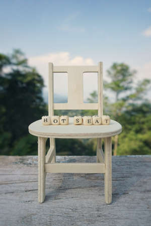 Conceptual - Vacancy and hot seat concept. â€˜HOT SEATâ€™ word written on wooden blocks and...