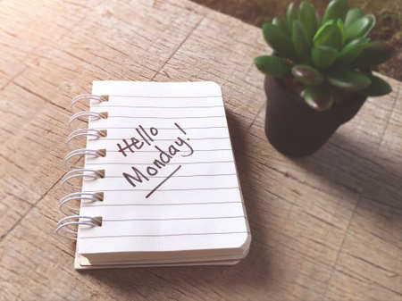 Inspirational words - Hello MONDAY written on a notepad. Blurred styled background.