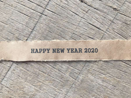 New Year concept  - Happy New Year 2020 written on a ripped white paper. Blurred styled background.