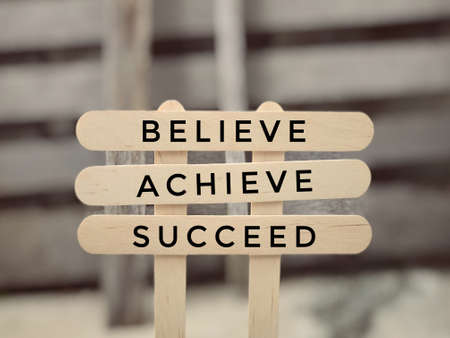 Motivational and inspirational wording - Believie, Achieve, Succeed. Blurred styled background.