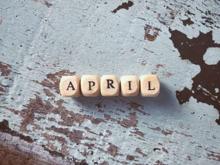 April written on wooden blocks and arranged on a wooden table.の写真素材