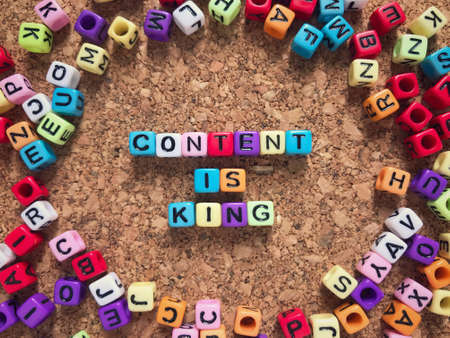 Motivational and inspirational quote - CONTENT IS KING wording form out of colorful toy blocks and arranged on a wooden table.の写真素材