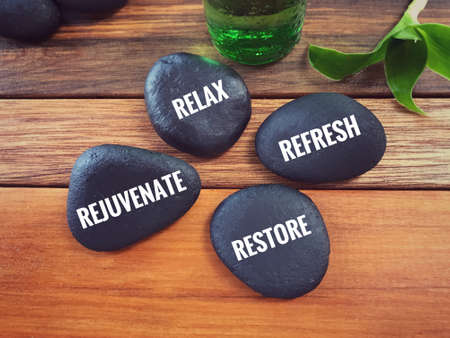 Motivational and inspirational words - Relax, Refresh, Rejuvenate, Restore written on pebbles.の写真素材