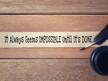 Motivational and inspirational wording - It Always Seems Impossible Until Itâs Done written on a ripped paper.の写真素材