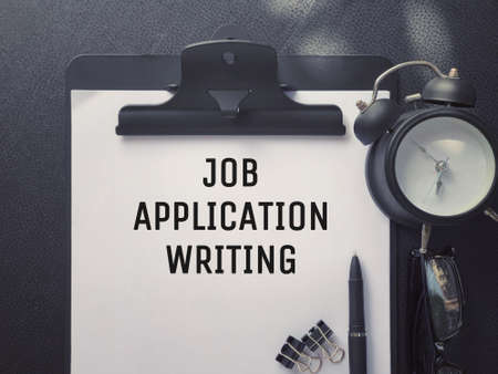 Business or Job Hiring concept - Top view of a clipboard and white sheet with JOB APPLICATION WRITING written on it.の写真素材