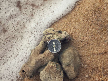 A compass on dead coral stones at a beach.の写真素材