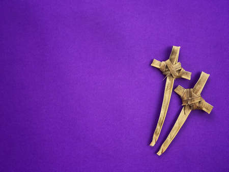 Good Friday, Palm Sunday, Ash Wednesday, Lent Season and Holy Week concept.  Christian crosses made of palm leaves on purple background.の写真素材