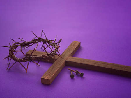 Good Friday, Lent Season, Ash Wednesday and Holy Week concept. A woven crown of thorns, three rusty nails and a Christian cross on purple background.の写真素材