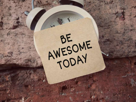 Motivational and inspirational wording. Be Awesome Today written on a paper that sticked on a clock....