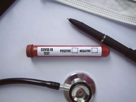 Medical and health care concept. COVID 19 TEST with result options written on a test tube. Vintage styled background.の写真素材