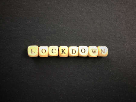 Public health and safety issues concept. LOCKDOWN written on wooden blocks. Blurred styled background.の写真素材