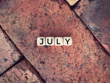 Time and month concept. JULY written on wooden blocks.の写真素材