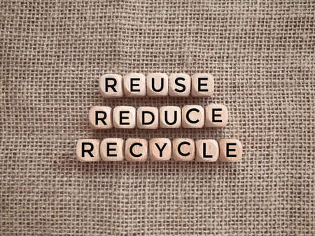 Environmental awareness and educational concept. REUSE, REDUCE and RECYCLE written on wooden blocks.の写真素材
