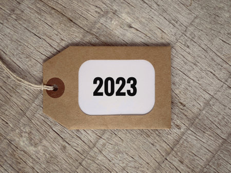New Year plan concept. 2023 written on a decorative tag. With blurred vintage styled background.の写真素材