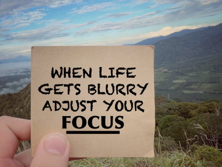 Motivational and inspirational wording. When Life Gets Blurry Adjust Your Focus written on a notepad. With blurred styled background.の写真素材