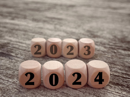 New Year Celebration Concept. Figure 2024 and blurry 2023 written on wooden blocks. With blurred...