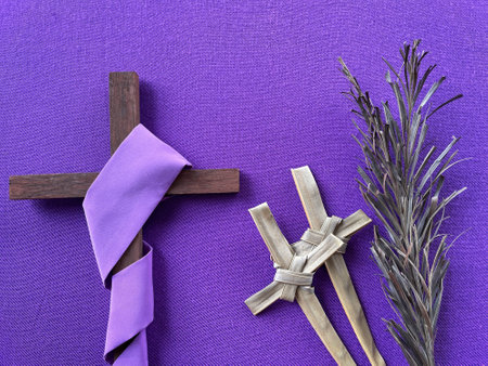 Christianity concept about Good Friday, Lent Season and Holy Week. Background of a dry palm leaves, a Holy Cross wrapped with purple cloth and Holy Crosses made of palm leaf.の写真素材