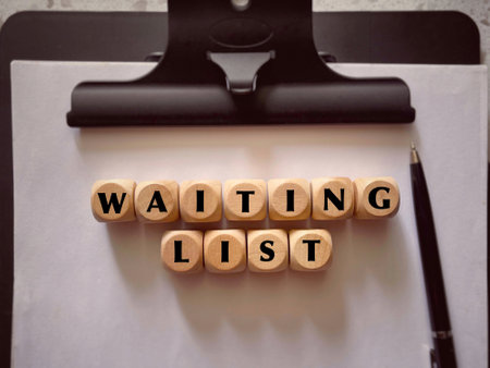 Business and work management concept. Waiting List written on wooden blocks. With blurred styled...