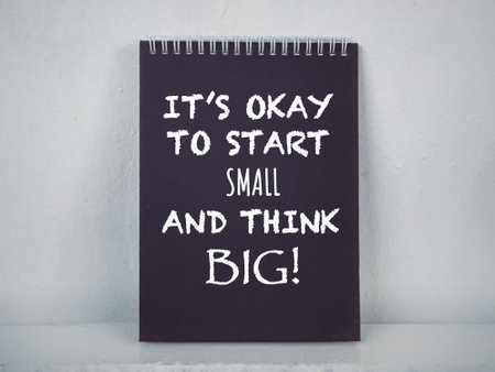 Motivational and inspirational wording. Itâs Okay To Start Small And Think Big written on a planner. With blurred styled background.の写真素材