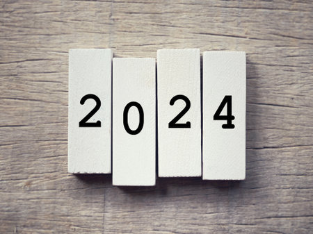 New Year Celebration Concept. Figure 2024 written on wooden blocks. With blurred styled background.