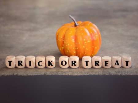 October celebration and Halloween concept. TRICK OR TREAT written on wooden blocks. With blurred styled background.の写真素材