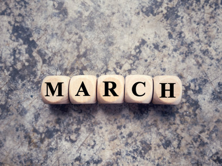 Month, time and celebration concept. MARCH written on wooden blocks. With blurred styled background.の写真素材