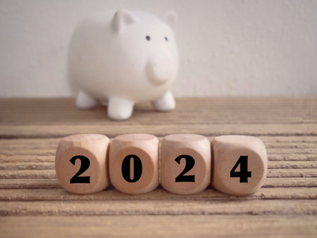 New Year financial plan concept. 2024 written on wooden blocks. With blurred styled background.の写真素材