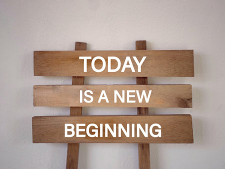 Motivational and inspirational wording. TODAY IS A NEW BEGINNING written on planks. With blurred styled background.の写真素材