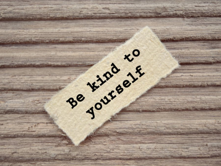 Motivational and inspirational wording. Be Kind To Yourself written on a paper. With blurred styled background.の写真素材