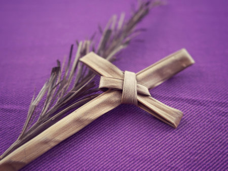 Christianity concept about Ash Wednesday, Good Friday, Lent Season and Holy Week. Holy cross made of palm leaf and a dry palm leaf arranged on purple background.の写真素材