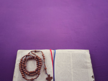 Christianity concept about church Liturgy, Ash Wednesday, Good Friday, Lent Season and Holy Week. A holy bible and a rosary arranged on purple background, blurred.の写真素材