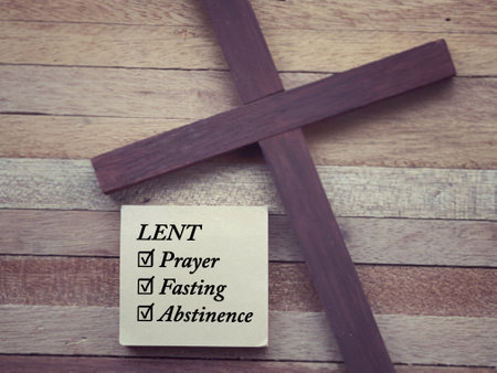 Christianity concept about Ash Wednesday, Good Friday, Lent Season and Holy Week. LENT, PRAYER, FASTING and ABSTINENCE written on a paper. With blurred style background.の写真素材