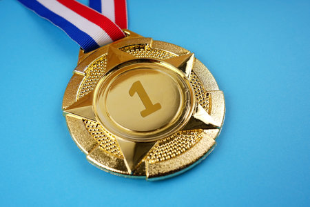 Motivational and inspirational concept. A gold medal placed on blue background.の写真素材