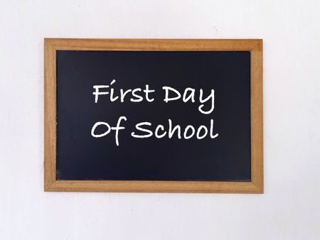 Student and education concept. First Day Of School written on a blackboard. Blurred styled...
