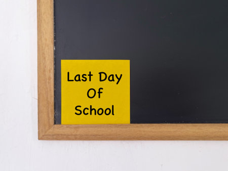 Student life and education concept. Last Day Of School written on adhesive paper. With blurred styled background.の写真素材
