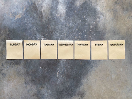 Day, time and calendar concept. SUNDAY, MONDAY, TUESDAY,WEDNESDAY, THURSDAY, FRIDAY and SATURDAY written on adhesive papers. On blurred styled background.の写真素材