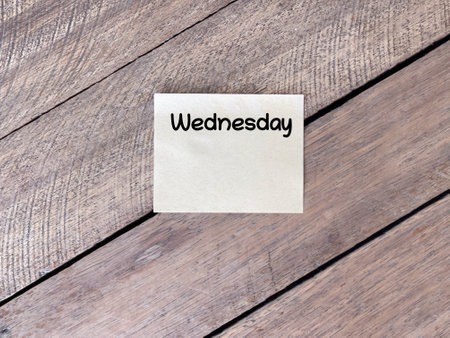 Day, time and calendar concept. WEDNESDAY  written on adhesive paper. On blurred styled background.
