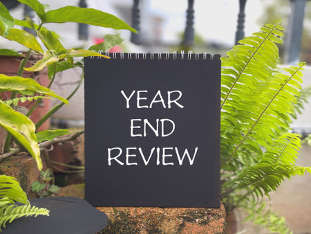 Motivational and inspirational new year concept. YEAR END REVIEW written on a notepad.の写真素材