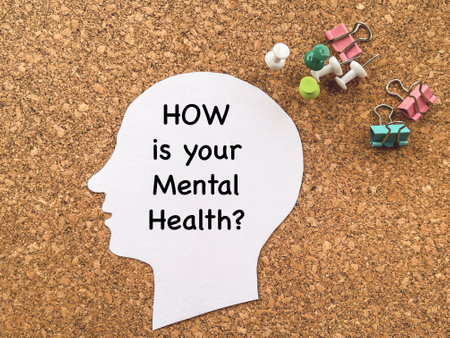 Health and medical care awareness concept. HOW IS YOUR MENTAL HEALTH text written on a human head cutout paper.の写真素材