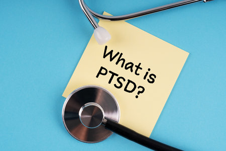 Stethoscope and yellow post-it note with text WHAT IS PTSDの写真素材