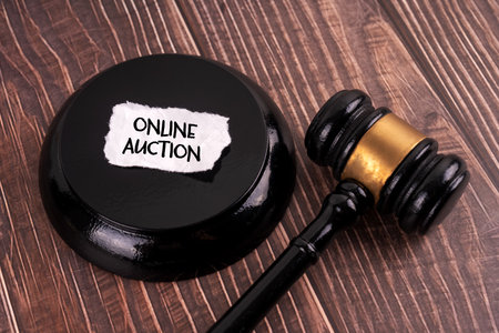 Wooden gavel and a piece of paper with the text ONLINE AUCTIONの写真素材
