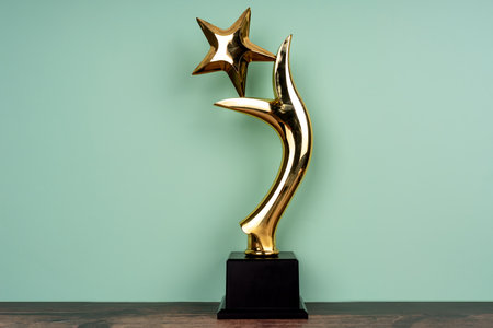 Standing golden trophy cup on light green backgroundの写真素材