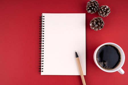 Empty notebook for copy space on red background with coffee and pine cones.の写真素材