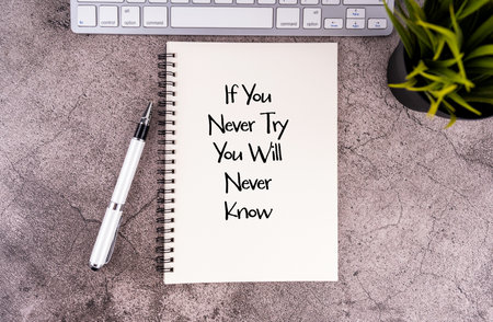 If You Never Try You Will Never Know written on a notepad. Inspirational wordingの写真素材