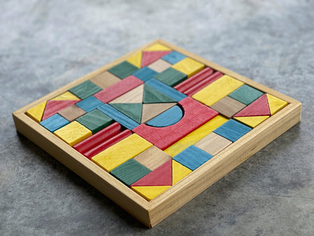 Colorful wooden geometric puzzle board representing educational toy and creative learning concept.