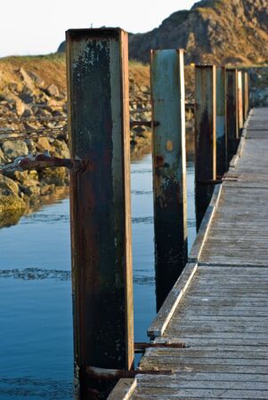 Rusting steel i-beams jut from the water to support the docks of the public boat launch in the Crescent City Harbor.の写真素材