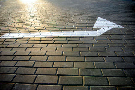  image of pointer  with an arrow painted on the roadの写真素材