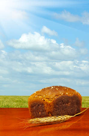 image of  bread and wheat on  field and sky backgroundの写真素材